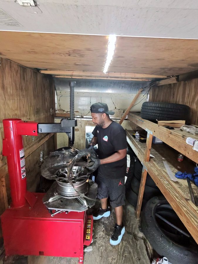 Migos Tires technician working a tire changer machine inside the mobile service van
